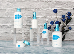 Белые стеклянные бутылки и банки с синими крышками